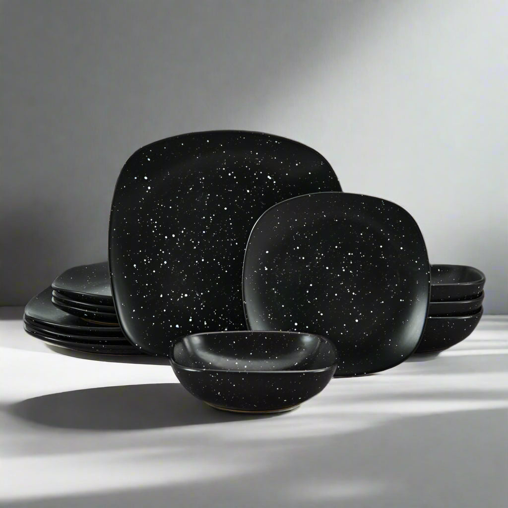 Close-up of galaxy-themed black square dinner plate with speckled glaze