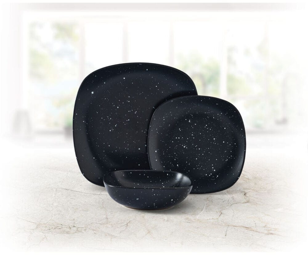 Close-up of galaxy-themed black square dinner plate with speckled glaze