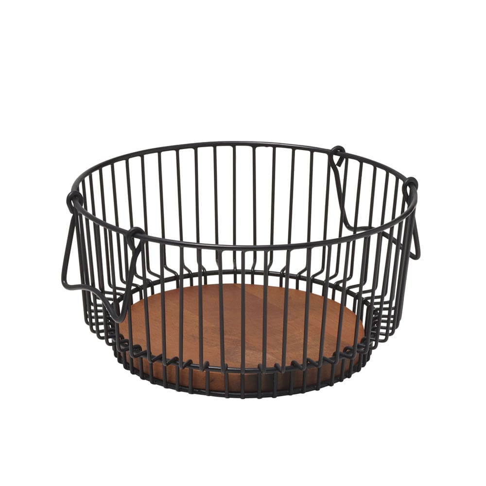 Side angle of the fruit basket placed on a kitchen island surrounded by fresh produce