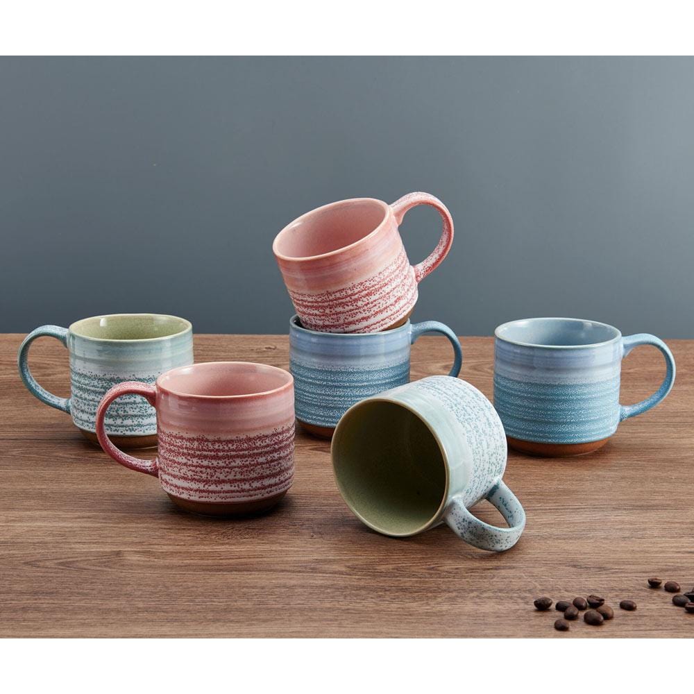 Close-up view of the brushed line design on a colorful stoneware mug, highlighting its craftsmanship and texture.