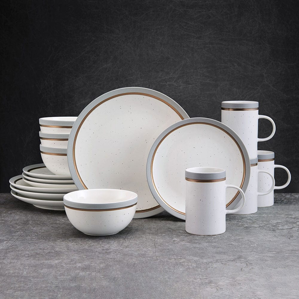 Modern speckled dinnerware set displayed on a dining table, showcasing plates and bowls.