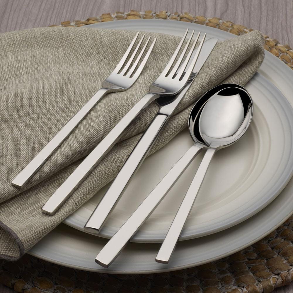 Close-up of stainless steel flatware set with slender handles and mirror finish
