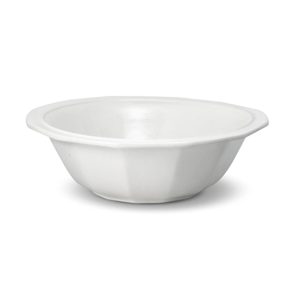 Family gathered around a table with the large stoneware serving bowl for dinner