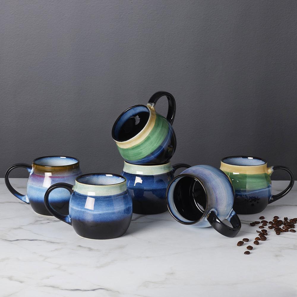 Set of six assorted ceramic mugs with varying designs
