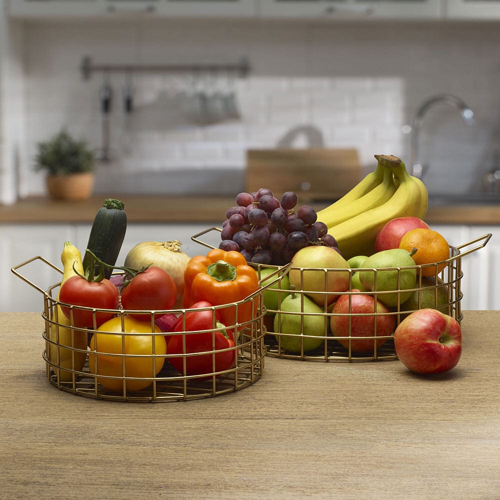 Close-up of gold wire centerpiece basket with fruit inside, showing intricate open-wire design