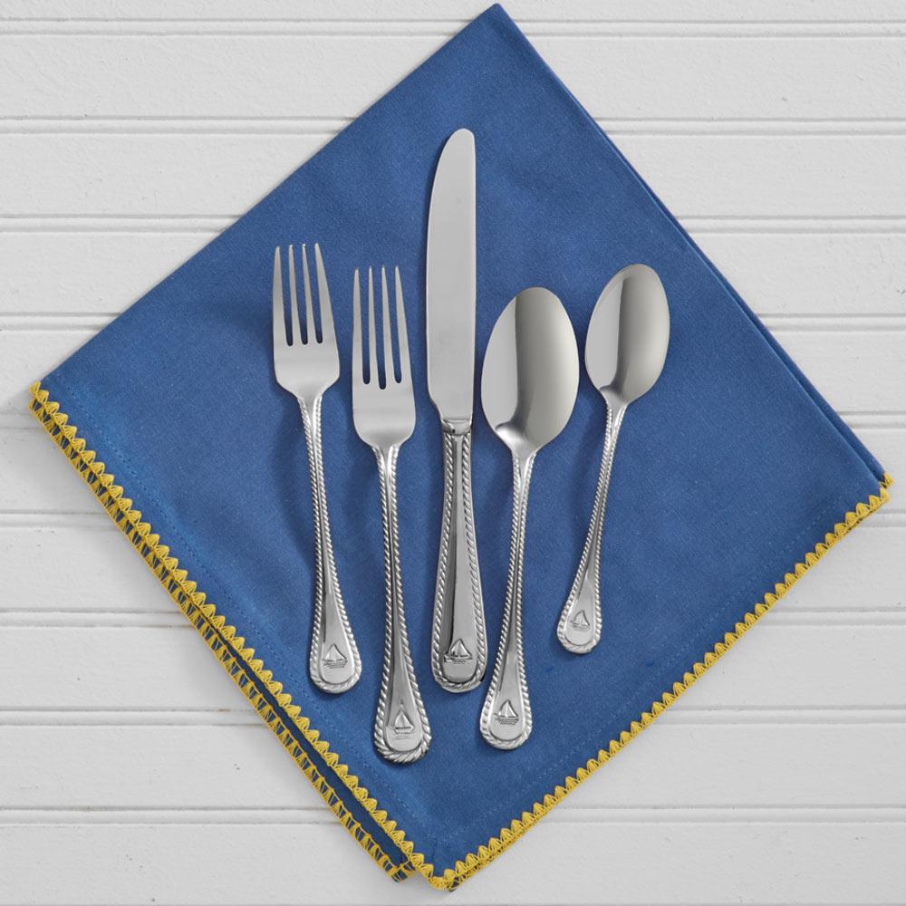 Close-up view of maritime stainless steel utensils with sailboat design.