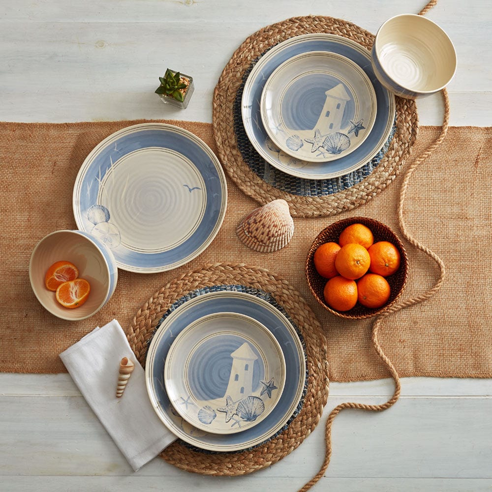 Top view of dinnerware set laid out for an outdoor picnic with plates, bowl, and napkins