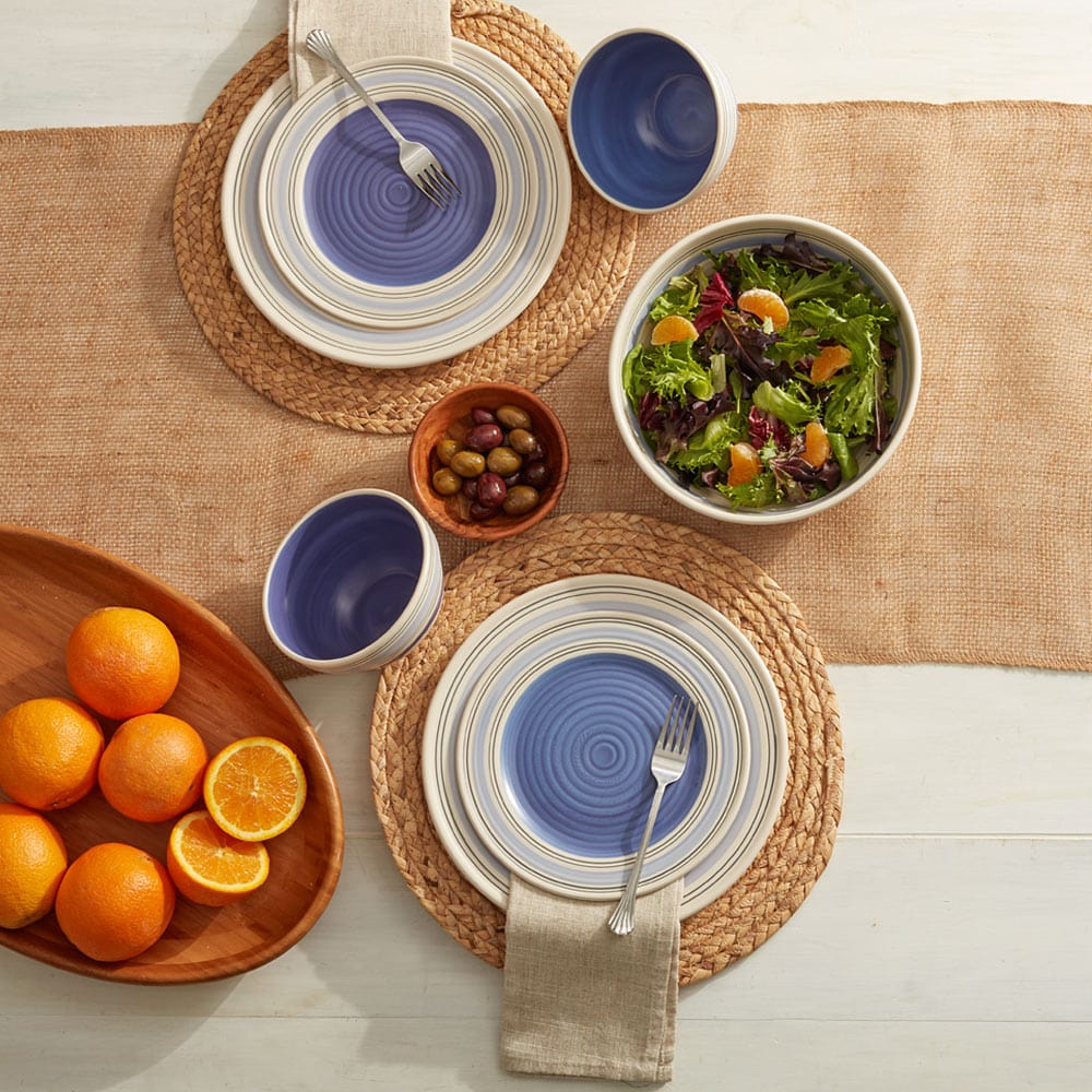 Rio stoneware dinnerware set featuring dinner plates, salad plates, bowls, and mugs, ideal for family dining.