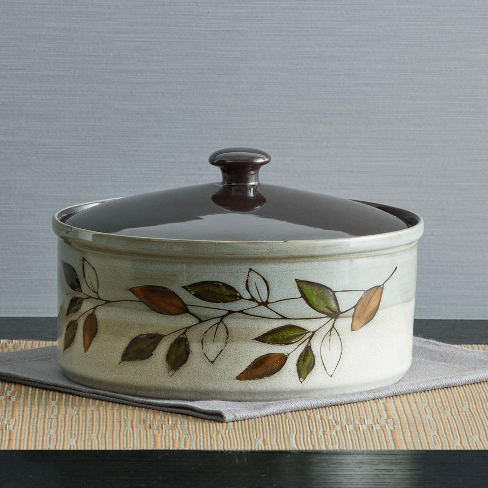 Close-up of rustic leaves pattern on stoneware casserole lid
