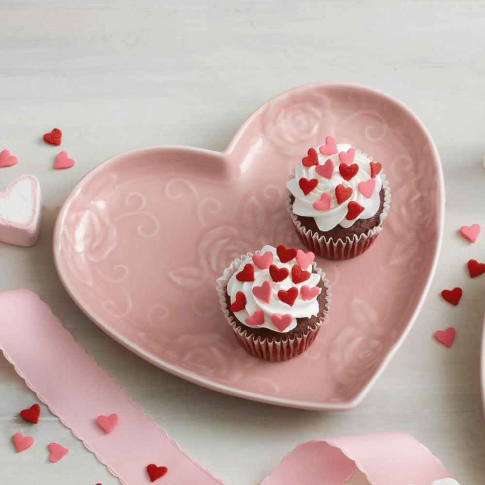 Close-up of pink heart shaped plate with embossed rose design for elegant table setting