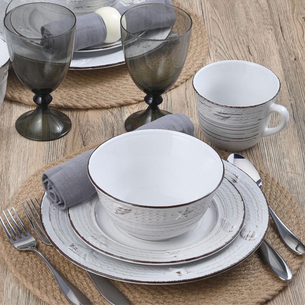Complete dinnerware set displayed with mugs and plates in an outdoor setting.