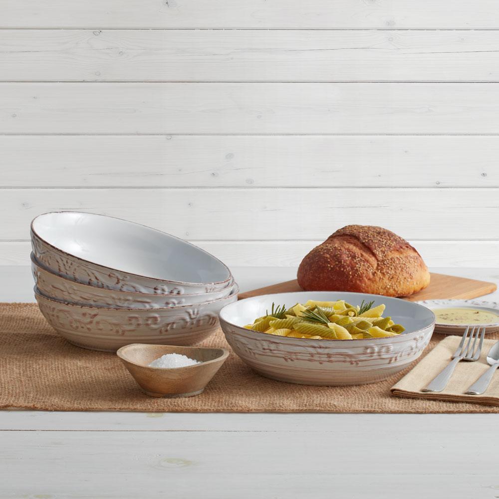 White stoneware pasta bowl with pasta and salad inside, close-up shot