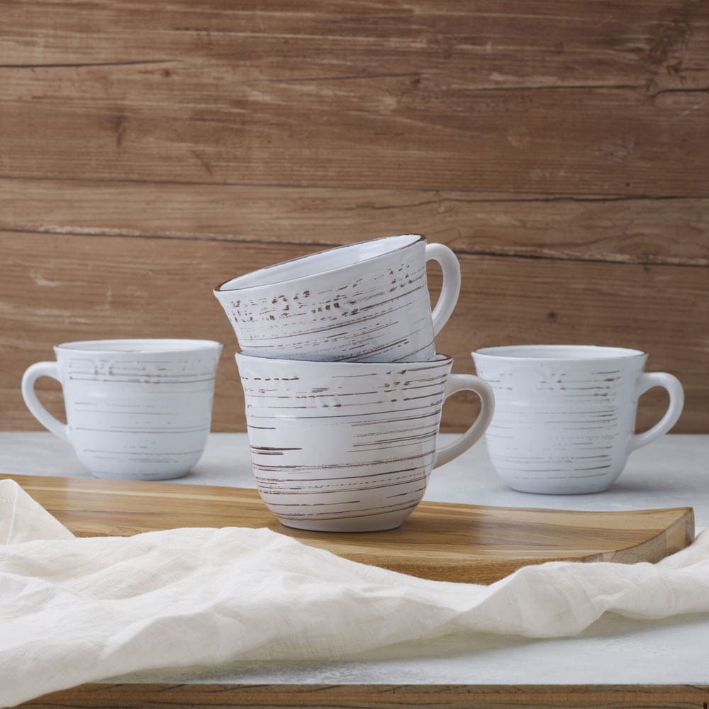 Front view of Trellis White stoneware mug set of 4 filled with coffee on a kitchen table