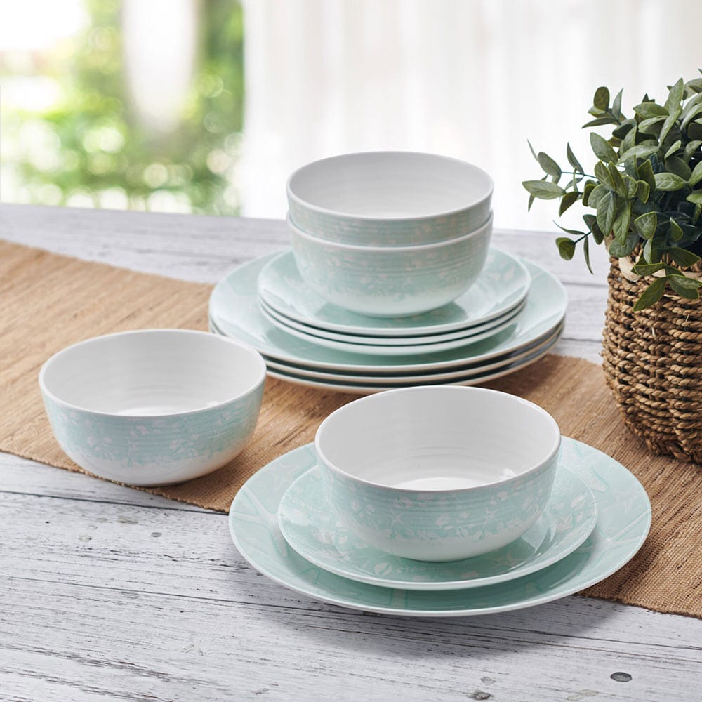 Coastal Breeze outdoor melamine dinnerware set displayed on a picnic table with vibrant starfish and seashell patterns.