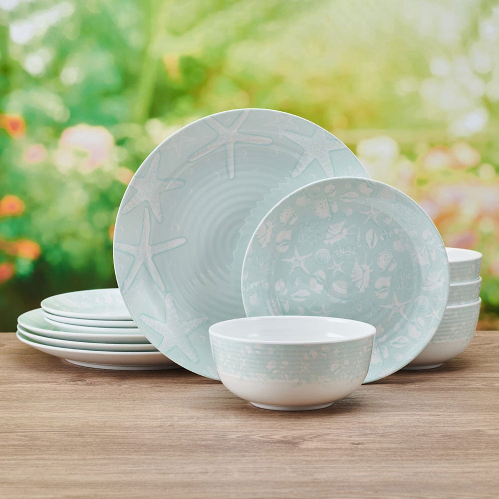 Close-up of the teal melamine plates and bowls showcasing their sturdy design and beach-themed artwork.