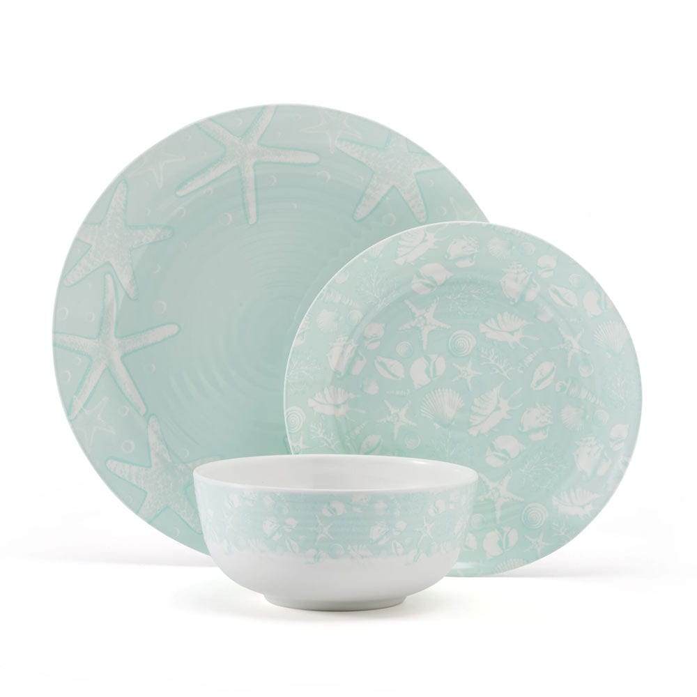 Coastal Breeze outdoor melamine dinnerware set displayed on a picnic table with vibrant starfish and seashell patterns.