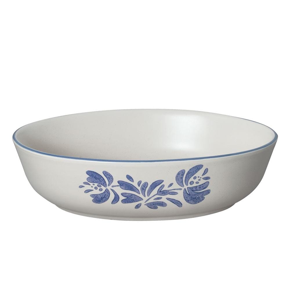 An overhead shot of the oval serving bowl filled with fruit salad on a dining table