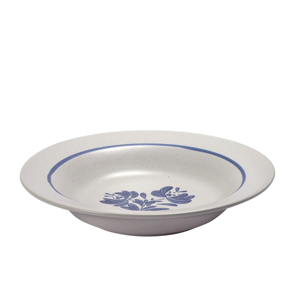 Stoneware bowl on a dining table, filled with hot soup, highlighting its durability and style
